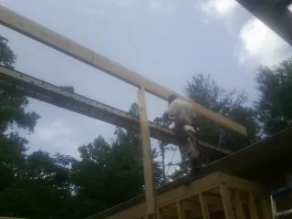 Carpenter setting a ridge beam over a new addition frame — Ice Dam Removal by Roofing Brothers in Newman