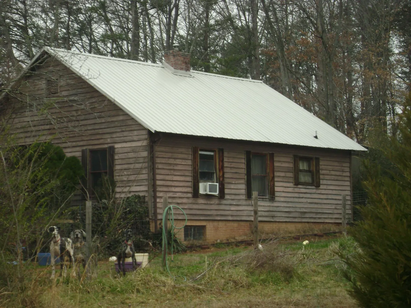 White metal roof on an old wood sided farmhouse, from a Metal Roof Installation job in Newman